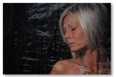 profile of a woman behind a wet window