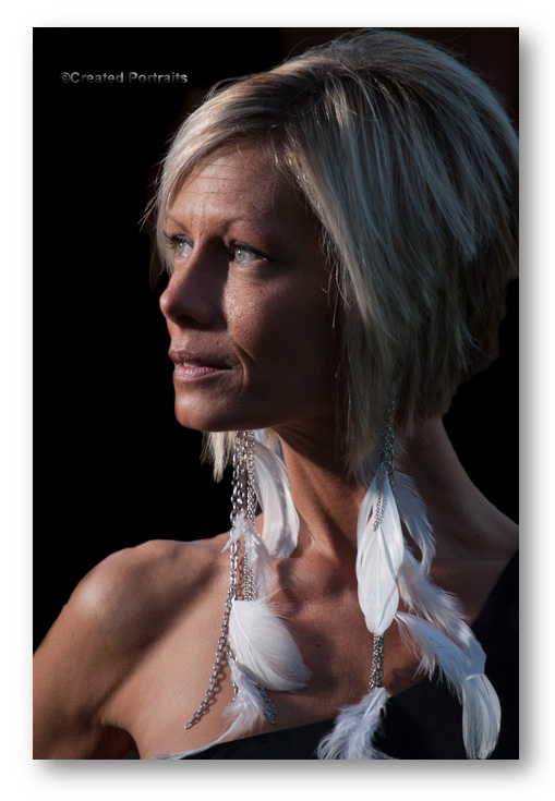 A low-image profile of a woman wearing feather earrings.